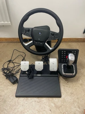 Hori Racing Wheel Apex med pedaler och växelspak - Komplett Hori Racing Wheel Apex set med ratt, pedaler och växelspak. Perfekt för realistisk bilkörning i racingspel. Flera knappar och reglage för avancerad kontroll. Produkten ser ut att vara i mycket gott skick utan synligt slitage eller defekter. Nypris 7599