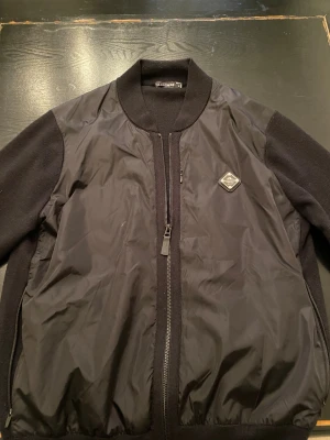 J Lindeberg cardigan i svart - Jag säljer en svart J Lindeberg cardigan i svart storlek M. Inga skador eller fleckar.