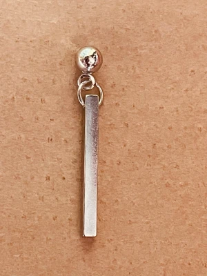 By prisförslag- 1 st örhänge silvrigt  - 1 st örhänge i silverfärgad metall med minimalistisk design. Ingen väst finns på bilderna.