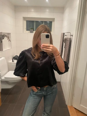 Svart Satinblus  - Supersöt satinblus från Vila. Storlek 38 men passar även mindre storlekar. Endast använd 2 gånger så precis som ny! Skriv för frågor💕