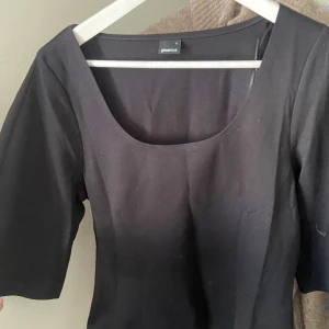 Svart topp  - Super fin topp med indragen midja och u-ringad upptill. Tröjan är ett lite hårdare material! Skriv för mer bilder på tröjan eller frågor!