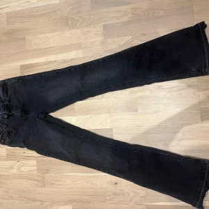 Svarta bootcut jeans från ONLY - Säljer ett par svarta jeans från ONLY med bootcut-modell. Jeansen har klassisk femficksdesign, knapp och dragkedja framtill samt svarta sömmar. Materialet är stretchigt jeans och passformen är normal med utsvängda ben.