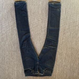 Nudie Jeans - Nudie jeans i nyskick utan defekter! Jeansen sitter slim och är i en snygg mörkblå färg som passar bra till allt! Priset kan diskuteras vid snabb affär! Jeansen är storlek 28 i midjan och 30 i längd. 