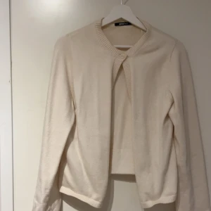 Beige kofta från Gina Tricot - Säljer en stilren beige kofta från Gina Tricot i storlek M. Koftan är stickad med rund halsringning och knäppning upptill. Perfekt att slänga över en topp för en enkel och clean look. Använd 2-3 gånger💞