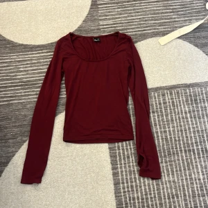 Vinröd långärmad topp Gina Tricot - Säljer en vinröd långärmad topp från Gina Tricot i storlek XXS. Toppen har en rundad halsringning och är figurnära i modellen. Perfekt att styla med jeans eller kjol för en enkel och snygg look.
