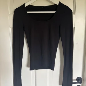 Svart långärmad topp Gina Tricot XS - En svart långärmad topp från Gina Tricot i storlek XS. Toppen har rund halsringning och är figurnära i modellen. Tillverkad i mjukt och stretchigt material som känns skönt mot huden. Den har slits på båda armarna. Perfekt att styla med jeans eller kjol för en clean look. Använd ett antal gånger men det är inget som märks på materialet. 