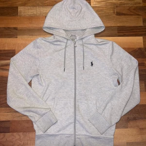 Ralph Lauren hoodie grå storlek XS (Kvitto) - Säljer min gråa Ralph Lauren hoodie i storlek XS från NK och kvitto finns. Den är knappt använd för jag gillar inte hur den sitter på mig. Den är i perfekt skick och har inget hål eller något. Om ni vill snacka om priset det bara att skriva.