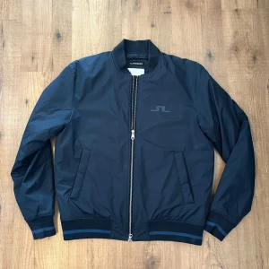 J Lindberg jacka - Säljer en sjukt fin jacka från j Lindberg! Den är helt oanvänd så den har inga skador eller tecken på användning. Storlek L. Jackan har jättesnygga detaljer. Nypris ca 3800kr mitt pris 1200kr🙌 vid frågor är det bra att kontakta mig!🤝