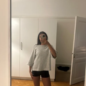 Grå stickad tröja  - Supermjuk grå stickad tröja från Pigalle i oversized modell. Tröjan har trekvartsärmar, rund halsringning och en loose fit som ger en chill vibe. Perfekt för lager-på-lager och funkar till allt. Snyggt ribbad vid halsen och i ett fluffigt material.