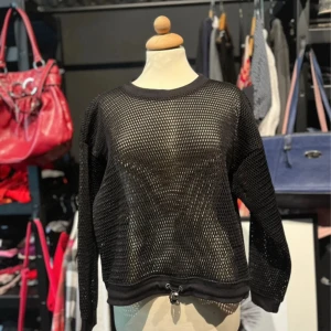 Svart nättröja från Monki  - Svart långärmad nättröja från Monki i storlek XS/S. Tröjan har ett sportigt nätmönster och dragsko nertill för justerbar passform. 