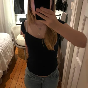 Mörkblå croppad topp med spetskant - Säljer en mörkblå croppad topp med korta ärmar och söt spetskant längs den v-ringade urringningen. Toppen har en tight passform och är tillverkad i mjuk bomull. Prislappen sitter kvar och har aldrig använts då det är fel storlek för mig. Pris kan diskuteras 💓