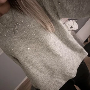 Grå stickad tröja med pärlor H&M - Supermysig grå stickad tröja från H&M med pärldetaljer upptill. nästan aldrig använd, inga pärlor tappade😌 skriv om bilder ellr frågor, tryck gärna på köp direkt💞