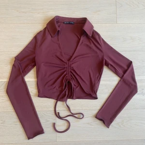 Vinröd croppad topp  - Använd 1 gång. Passar även någon i XS. Justerbara band i mitten av tröjan. Jätte fin färg. Stretchigt och luftigt tyg.  Vänligen läs min bio innan du gör ett köp; där hittar du bland annat information om leveransprocessen med mera 😊