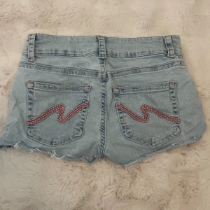 Low waist jeans shorts  - Lågmidjade jeans shorts med detaljer på bakfickorna från Nelly. Använda vid 2 tillfällen. Stretchigt material. Köpta för 499kr
