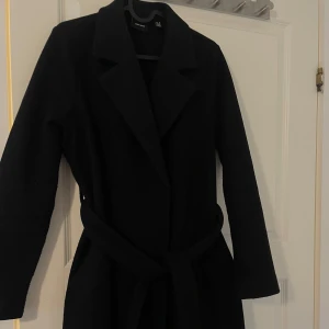 Svart kappa med bälte från Vero Moda - Säljer min kappa från vero Moda, säljes pga att den nu är för liten för mig 