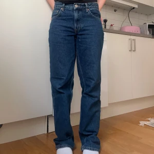 Blå raka jeans från Gina Tricot - Säljer ett par klassiska blå jeans från Gina Tricot, modell Perfect Jeans. De har rak passform, medelhög midja och fem fickor. Jeansen är tillverkade i kraftigt denimtyg och har snygga kontrastsömmar samt läderpatch bak i midjan.