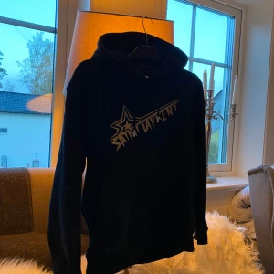 Saint Laurent hoodie - Säljer en svart hoodie från Saint Laurent med ett tryck i guld på framsidan. Strl S. Den är inte så använd, så skulle kunna säga att skicket är 9/10