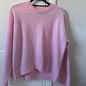 Ljusrosa stickad tröja med rund hals - Supermjuk och fluffig ljusrosa stickad tröja med rund halsringning från gina. Tröjan har ribbade muddar vid hals, ärmslut och nederkant. Har endast använt 1 gång därav säljer jag den💗storlek 170