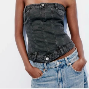 Svart jeans tubtopp från Zara  - Jätte snygg svart tubtopp i jeansmaterial från Zara i storlek XS men passar även som S. Toppen har bälteshällor, knappdetaljer och låtsas fickor framtill, samt smock och dragkedja bakom. Topen var köpt för 380kr men säljs eftersom den inte kom till användning! 