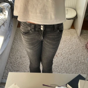 Grå bootcut jeans från H&M, stl 158 - Snygga grå jeans från H&M med bootcut-ben och låg midja. Jeansen har justerbar midja och dubbla knappar fram! Jättefina för höst!🍂💞