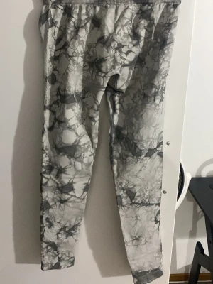 Define seamless Tie Dye tights  - Säljer ett par grå träningstights med coolt marmorerat mönster i olika nyanser av grått och svart. Tightsen har en elastisk midja och är tillverkade i ett syntetmaterial som andas, perfekt för gymmet eller löprundan.