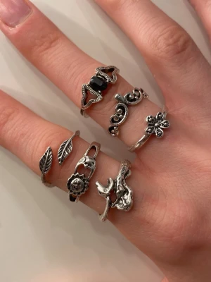 Snygga silvriga ringar  - Säljer ett set med flera silvriga ringar i olika coola designer. Några har blommor, blad och organiska former, andra annat. Perfekt för att mixa och matcha på alla fingrar. Ej äkta silver 🫶styckpris 6kr, alla för 30kr!