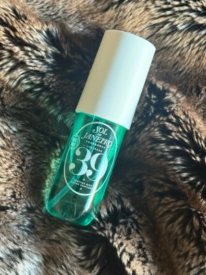 Sol de Janeiro Cheirosa 39 Mist - Fragrance mist med tropisk vibe från Sol de Janeiro. Volym: 90 ml. Cheirosa 39 doften har en toppnot av kokosnötskräm, följt av hjärtnoter av varm vanilj och tropisk orkidé. I basen av doftprofilen finns noter av krämigt sandelträ och rostad pralin.  Inspirerad av Carmen Miranda och hennes signaturfrukthuvudbonad är Sol de Janeiro Cheirosa 39 Perfume Mist en ikonisk gourmanddoft med måttlig projektion.  