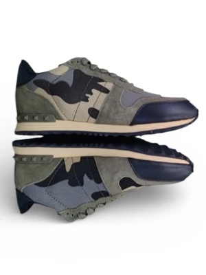 Valentino Rockrunner sneakers camouflage - Säljer ett par Valentino Rockrunner sneakers med grått och blått camouflage-mönster. Skorna har detaljer i mocka och skinn, samt coola nitar på hälen. Snygg platt sula och rund tå. Kommer med originalkartong i matchande camo. Perfekt för dig som gillar streetstyle och designer.