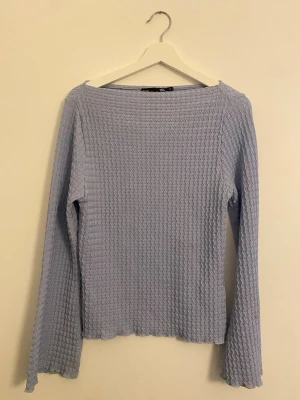 Ljusblå långärmad topp med struktur - Stl M - Säljer en ljusblå långärmad tröja från 157 med vågigt ribbad struktur. Tröjan har en rak passform och lätt croppad längd, perfekt till jeans eller kjol. Enkel att klä upp eller ner. I fint skick.