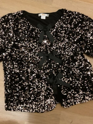 Paljett blus - Paljett blus från gina young med rosetter 