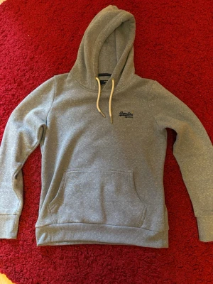 Ljusblå Superdry hoodie -  Ljusblå super Dry hoodie i storlek XS / XS, aldrig använd och passar till alla tillfällen. Hör av dig vid åtminstone värdering och jag fraktar alltid en till två dagar efter beställningen!