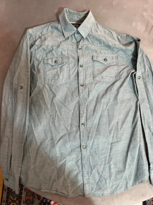 Ljusblå skjorta LCW - Säljer en ljusblå skjorta från LCW Casual. Skjortan har två bröstfickor med knappstängning, klassisk krage och långa ärmar med knappdetaljer. Perfekt för dig som gillar stilren look. Du behöver bara stryka skjortan sen blir den som ny annars så kan du returnera den direkt 