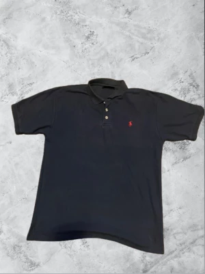 Polo Ralph Lauren - Snygg mörkblå pikétröja från Ralph Lauren med klassisk krage och tre knappar framtill. Sälja på grund av för stor🤗