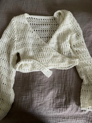 Vit stickad omlottkofta med knyt - Vit omlottkofta, använd 2 gånger.