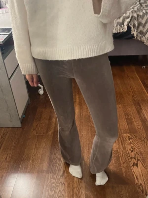 Bruna bootcut byxor - Säljer ett par bruna bootcut-byxor. De har en hög midja och sitter tajt över låren innan de blir vidare nedtill. Perfekta om du gillar retrovibbar och vill ha något som sticker ut lite. Supersköna och snygga till sneakers eller boots.