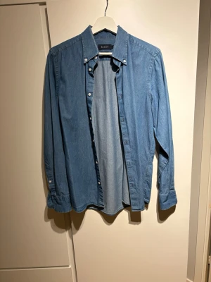 Blå slim fit skjorta från Riley - Snygg blå skjorta från Riley i slim fit-modell. Skjortan har klassisk krage, långa ärmar med manschett och knappar framtill. Storlek: M. Riktigt fint och bra skick. Skriv om funderingar!