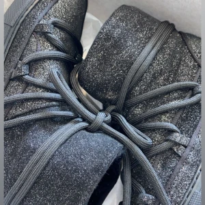 Svarta glittriga Inuikii i mocka - Inuikii skor i superfint skick!! Använda endast ett fåtal gånger,  inga stora tecken på slitage. De är svarta mocka med skimmer/ glitter. Nypris 2800kr, säljes för 1350kr. Skorna är både varma och snygga, samt perfekta för höst och vinter.💕