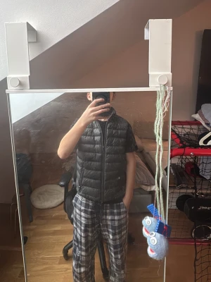 Svart dunväst från Polo Ralph Lauren - Säljer en svart dunväst från Polo Ralph Lauren i storlek 10-12 år. Västen har quiltad design, dragkedja framtill och två sidofickor med dragkedja. Perfekt för lager-på-lager och har en clean, sportig look som funkar till många stilar.