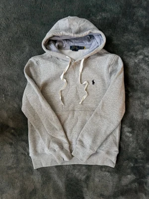 Ralph lauren hoodie  - Grå Ralph Lauren hoodie med vita snören i skön och tjock kvalitet, klassisk modell med bekväm passform ✅