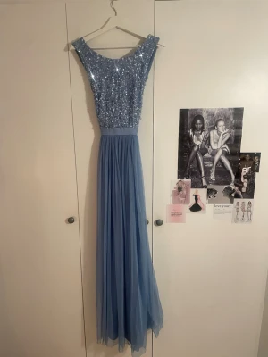 Balklänning - Så så fin balklänning med paljetter från Maya deluxe i storlek 34. Är djup och korsad i ryggen och har band som man knyter till en rosett. Banden har två slitage märken på insidan av banden (bild 4) men syns inte när man knyter rosetten🩵🩵🩵