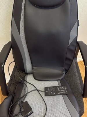 Svart och grå massageväst från Snailax - Massageväst från Snailax i svart och grått med stilrena linjer och meshdetaljer. Västen har inbyggd fjärrkontroll med funktioner för värme, vibration och olika massagezoner. Materialet är syntet och mesh, perfekt för att chilla och få massage hemma.