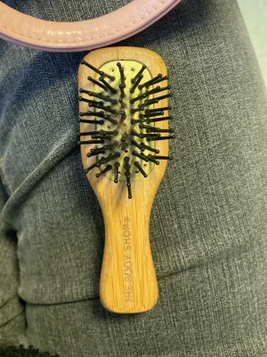 Värdens sötaste The body shop borste - Bilderna visar en hårborste från The Body Shop i trä, den funkar som livräddaren till vardagens tovor i håret, den är super söt och men lite använd, när du får hem den så är den ren, och har inga hårstrån på sig, den är alltså fräsch när den är påväg att förvaras i din handväska!❤️