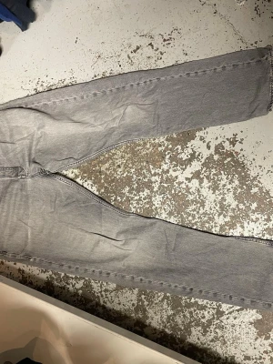 Gråa jeans från Jack & Jones - Säljer ett par gråa jeans från Jack & Jones med klassisk femficksdesign och raka ben. Jeansen är tillverkade i bomull och har en snygg tvättad look. Passar dig som gillar enkel och stilren denim med lite edge.