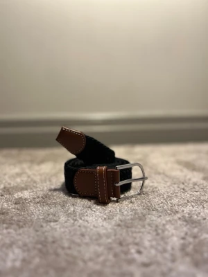 Flätat bälte svart - Ett stilrent flätat bälte från Ragazzo i en klassisk svart färg. Bältet är 105 cm långt och tillverkat i slitstarkt material som ger både komfort och hållbarhet. Den flätade designen gör bältet lätt att justera för optimal passform och passar lika bra till vardag som till mer uppklädda tillfällen.⚫️⚫️🍾🍾