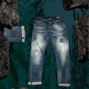 Blå selvage jeans med patch och slitningar - Snygga blå jeans med coola slitningar och en patch på framsidan. Jeansen har uppvikta benslut och en tvättad look med ljusa partier. Klassisk femficksmodell och raka ben. Perfekt för dig som gillar en avslappnad och trendig stil.