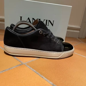 Mörkblå Lanvin  - Tjena, jag säljer nu dessa sjukt snygga mörkblå lanvin skor i storlek Uk6. De är sparsamt använda, och det finns vissa tecken på användning. Man får med boxen. Priset kan även diskuteras! Hör av dig ifall du har frågor eller funderingar!🤩