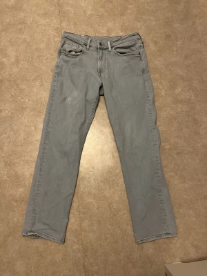 Ljusblå regular fit jeans från H&M - Säljer ett par ljusblå jeans från H&M i regular fit. Klassisk femficksmodell med raka ben och normal passform. Jeansen har knapp och dragkedja framtill samt bälteshällor. Perfekt för dig som gillar enkel och stilren denim.
