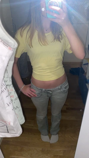 Gul croppad topp med knyt från 157 - Säljer en ljusgul croppad topp från 157 i storlek M. Toppen har korta ärmar och en öppen rygg med snyggt knytband bak. Perfekt för dig som gillar en chill och trendig stil. Materialet är mjuk bomull som känns skönt mot huden. Den som man knyter är egengjort.