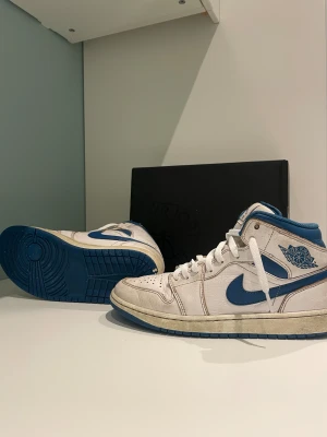 Nike Air Jordan 1 mid industrial blue - Nike air jordan 1 mid. Industrial blue nike air i helt okej skick. Nya snören samt originalkartongen med pappret kvar, har ej kvitto då de var en present från mina föräldrar men är köpta från Nike. Har några mindre skador men är ändå snygga. Köptes för typ ett år sedan för typ 2000kr. Tveka inte att höra av er vid minsta frågor! 