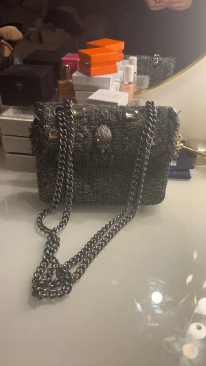 Svart axelväska från Kurt Geiger - Säljer en snygg svart axelväska från Kurt Geiger med grov kedja i silver och dekorativa stenar på. Pris går att diskutera❤️